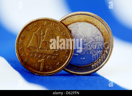 An one-euro coin and a Greek drachma stand on their edges on an illuminated table in Cologne, Germany, 21 May 2012.Speculation is ramopant about a possible withdrawal of Greece from the eurozone. Photo: Oliver Berg Stock Photo