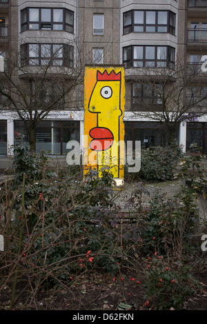 A painted section of the old Berlin wall standing in a pedestrian precinct, near Checkpoint Charlie in central Berlin. The Berlin Wall was a barrier constructed by the Communist German Democratic Republic (GDR, East Germany) starting on 13 August 1961, that completely cut off (by land) West Berlin from surrounding East Germany and from East Berlin. Stock Photo