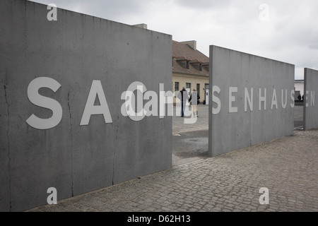 A tourist couple enter the Sachsenhausen Memorial and Museum. Sachsenhausen was a Nazi and Soviet concentration camp in Oranienburg, 35 kilometres (22 miles) north of Berlin, Germany, used primarily for political prisoners from 1936 to the end of the Third Reich in May 1945.  (More caption in Description). Stock Photo