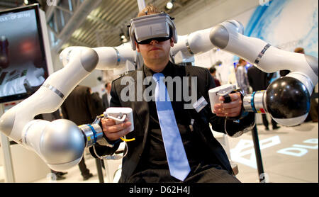 An employee of the DLR operates robot Justin developed by the German Aerospace Center (DLR) at Automatica 2012 in Munich, Germany, 22 May 2012. In the future, Justin will be remote controlled from the earth to work in space. Automatica takes place from 22 until 25 May 2012. Photo: SVEN HOPPE Stock Photo