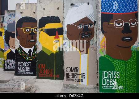 World dictators adorn old sections of the old Berlin Wall opposite the former Checkpoint Charlie, the former border between Communist East and West Berlin during the Cold War. The Berlin Wall was a barrier constructed by the German Democratic Republic (GDR, East Germany) starting on 13 August 1961, that completely cut off (by land) West Berlin from surrounding East Germany and from East Berlin. .. (More in Description). Stock Photo