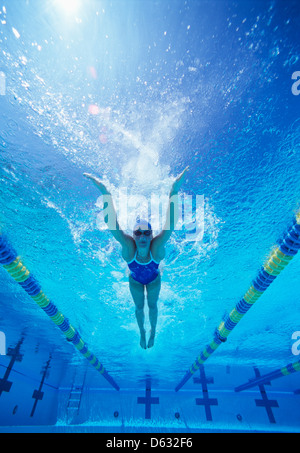 Full length of female swimmer in United States swimsuit swimming in pool Stock Photo