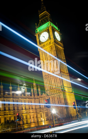 A night scene which shows the Big Ben clock, while light streaks are made by a passing bus, done by a long exposure effect Stock Photo