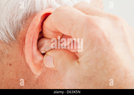 Close up of senior man's ear with hearing aid Stock Photo