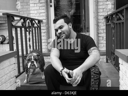 Man with his trusted bloodhound on the stoop of his home, Williamsburg, Brooklyn. NYC Stock Photo