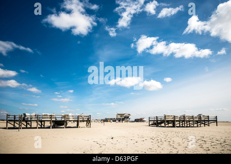 Sandy beach with beach chairs and buildings in St. Peter-Ording at the North Sea in Germany on a sunny day in spring Stock Photo