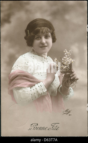 Old Swiss postcard 1917. Shows a girl with flowers. The inscription in French: Happy Birthday Stock Photo