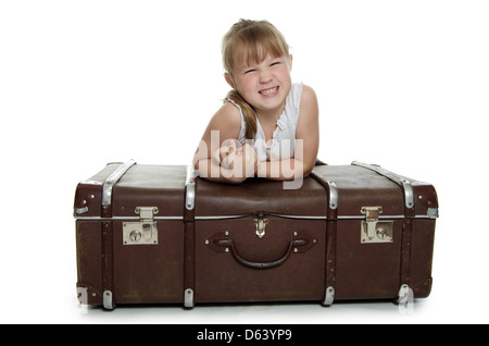 The little girl on old suitcases Stock Photo