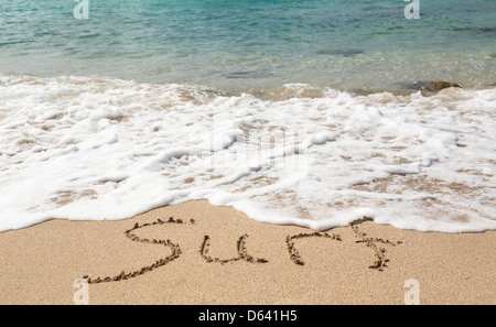 Sand drawing on warm beach by ocean surf in Caribbean spelling Surf Stock Photo