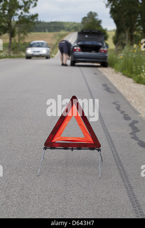 Warning triangle on the road before car Stock Photo
