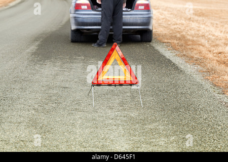 Warning triangle on the road before car Stock Photo
