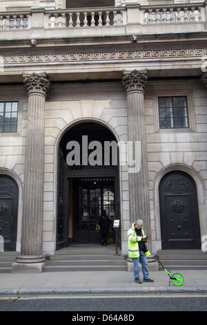 surveyor measuring distance outside bank of england, City of London, UK Stock Photo