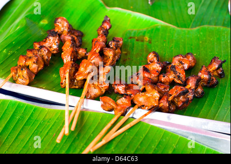 Traditional Thai food at market. Delicious spicy grilled chicken fillet on sticks Stock Photo