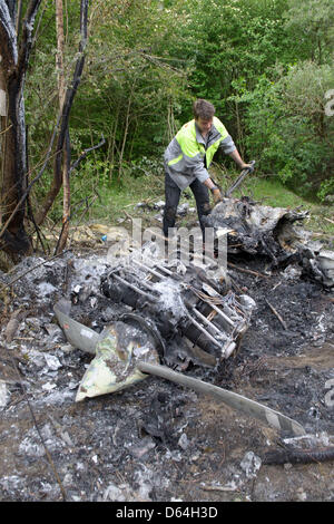 Helpers carry the wreckage of a crashed small plane in Constance, Germany, 27 May 2012. According to an eye witness, the plane touched some trees nearby after takeoff and caught fire. The pilot and another person could escape from the wreck but are severely injured. Photo: TOBIAS KLEINSCHMIDT Stock Photo