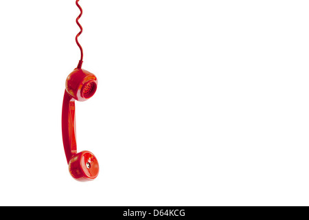 A red telephone receiver dangling by it's cord. Stock Photo