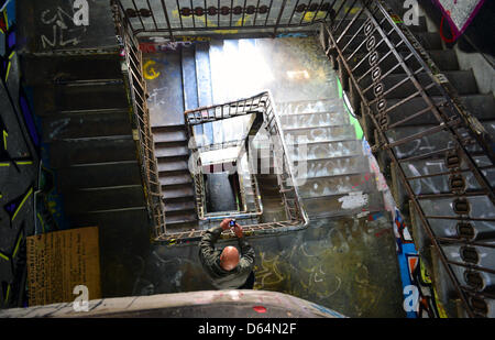 A tourist takes a picture of the staircase at Art House Tacheles in Berlin, Germany, 31 May 2012. The home to alternative art and culuture scenes used to be a shopping center. The building was damaged in the war and because it was in the way of GDR city planning, it was demolished step by step. In February 1990 50 artists from East and West Germany squatted the building, saving the Stock Photo