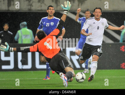 Germany's Mesut Oezil (R) and Israel's goalkeeper Ariel Harush (L) vie for the ball during the international friendly soccer match Germany vs Israel at Red Bull Arena in Leipzig, Germany, 31 May 2012. Photo: Hendrik Schmidt dpa/lsn  +++(c) dpa - Bildfunk+++ Stock Photo