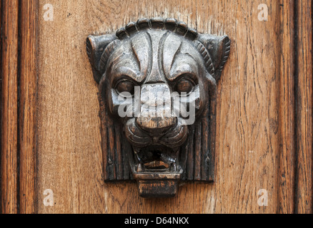 Wooden lion head relief - decorative element on ancient weathered door in old part of Tallinn, Estonia Stock Photo