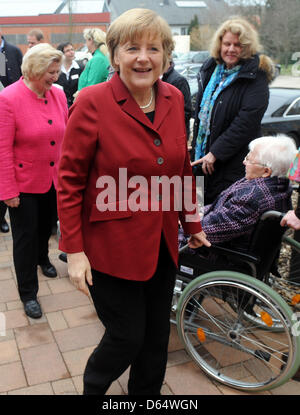 Melle-Wellingholzhausen, Germany. 12th April 2013. German Chancellor Angela Merkel (C) greets elderly people sitting in a wheel chair at the senior centre St. Konrad Melle-Wellingholzhausen, Germany, 12 April 2013. Merkel gathered information on the concept of retirement centres, in which elderly people can live together in communities. Photo: Ingo Wagner/dpa/Alamy Live News Stock Photo