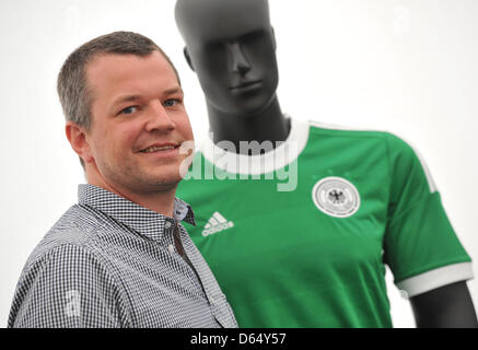 Bjoern Jaeger, chief designer of football jerseys at Adidas, poses next to the German away jersey after a press conference of the sponsor of the German national soccer team, Adidas, at hotel Dwor Oliwski in Gdansk, Poland, 6 June 2012. The UEFA EURO 2012 will take place from 08 June to 01 July 2012 and is co-hosted by Poland and Ukraine. Photo: Andreas Gebert dpa Stock Photo