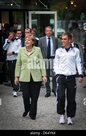 HANDOUT - Bundeskanzlerin Angela Merkel und der Kapitän der deutschen Fußballnationalmannschaft, Philipp Lahm, gehen am Mittwoch (06.06.2012) zum gemeinsamen Abendessen mit der Nationalmannschaft im EM-Quartier. Kanzlerin Angela Merkel stattete den deutschen EM-Spielern einen Besuch im Europameisterschafts-Quartier ab. Foto: Pool / Bundesregierung / Bergmann dpa Stock Photo