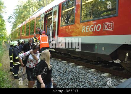 Passengers exit a damaged regional train heading from Lueneburg to Luebeck after it crashed into a tree that had fallen onto the tracks near Guester, Germany, 18 June 2012. None of the 48 passengers were harmed, according to a spokesman of the police. Photo: Christian Nimtz Stock Photo