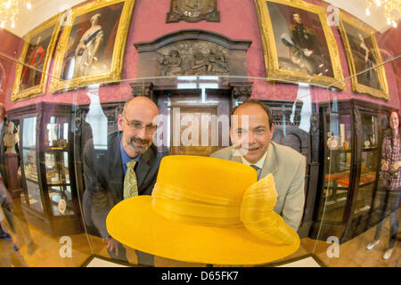 Martin Eberle (L), director of the Friedenstein Palace Foundation, and Knut Kreuch, Lord Mayor of Gotha, present an original hat of British Queen Elizabeth II at the Friedenstein Palace Museum in Gotha, Germany, 19 June 2012. The unusual exhibition piece is part of the exhibition 'Fairy Tale Palace Friedenstein' and with be regularly replaced with a new hat of the Queen. Photo: Mic Stock Photo