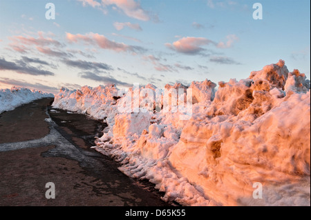 Snowdrifts on Stonewall Hill, nr Knighton, Powys, UK, at sunset in the late winter of 2013. The lane follows the border between England and Wales Stock Photo