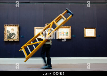 London, UK. 12th April 2013. A Sotheby's employee walks by with a ladder in front of  impressionist paintings including 'Les Pommes' by Paul Cezanne that will go on sale at Sotheby’s New York in May 2013. The Blockbuster sales at include works by Richter, Modigliani, Picasso, Rodin, Bacon, Cezanne. Credit: Piero Cruciatti / Alamy Live News Stock Photo