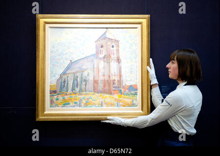 London, UK. 12th April 2013. A Sotheby's employee poses in front of  Piet Mondrian 'Church in Zouteland' (Est. $500.000-700.000). The work will go on sale at Sotheby’s New York in May 2013. The Blockbuster sales at include works by Richter, Modigliani, Picasso, Rodin, Bacon, Cezanne. Credit: Piero Cruciatti / Alamy Live News Stock Photo