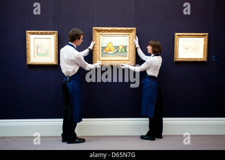 London, UK. 12th April 2013. Sotheby's employees pose in front of 'Les Pommes' by Paul Cezanne (Est. $25-35 million). The work will go on sale at Sotheby’s New York in May 2013. The Blockbuster sales at include works by Richter, Modigliani, Picasso, Rodin, Bacon, Cezanne. Credit: Piero Cruciatti / Alamy Live News Stock Photo