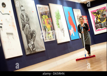 London, UK. 12th April 2013. a Bonhams sales assistant works next to canvas during the 'Urban Art' auction preview. Credit: Piero Cruciatti / Alamy Live News Stock Photo