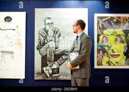 London, UK. 12th April 2013. a Bonhams employee poses next to a canvas by Jef Aerosol entitled 'Keith Haring' during the 'Urban Art' auction preview at Bonhams. Credit: Piero Cruciatti / Alamy Live News Stock Photo