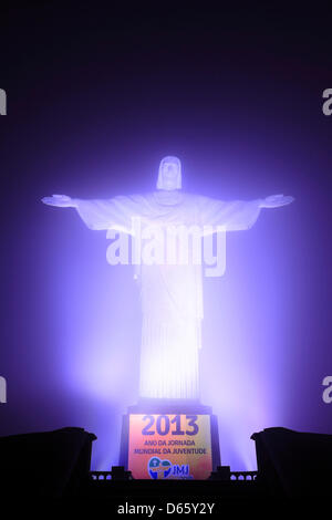 The illuminated Cristo Redentor statue on top of Corcovado with an invitation to the World Youth Day 2013 in Rio de Janeiro Stock Photo