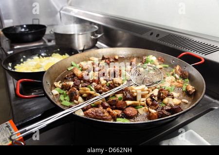 Cooking Paella, a traditional Spanish dish of rice, chicken, pork, seafood, peppers and beans Stock Photo