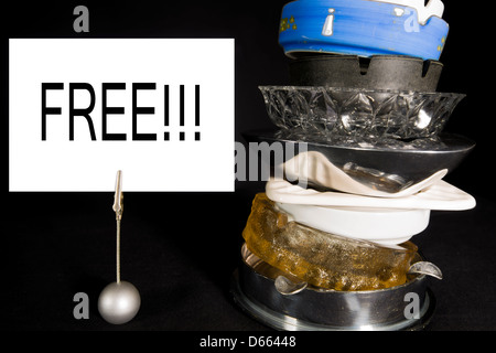 Stack of old ashtrays with a 'Free' sign indicating the owner has successfully quit smoking and no longer needs them. Stock Photo