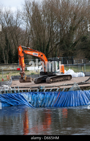 A mechanical digger working on a riverside construction project. Stock Photo