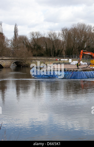 A mechanical digger working on a riverside construction project. Stock Photo