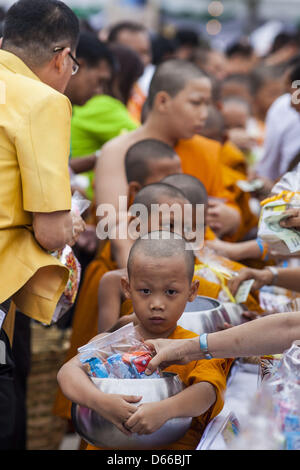 Bangkok, Thailand. April 13, 2013. Thai novice monks receive alms during a merit making ceremony for Songkran at the Bangkok City Hall. Songkran is the traditional Thai New Year's Festival. It is held April 13-16. Many Thais mark the holiday by going to temples and making merit by giving extra alms to monks or offering extra prayers. They also mark Songkran with joyous water fights. Songkran has been a national holiday since 1940, when Thailand moved the first day of the year to January 1. (Credit Image: Credit:  Jack Kurtz/ZUMAPRESS.com/Alamy Live News) Stock Photo