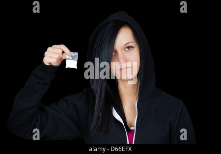 Gloomy young woman or teen addict with drugs on black Stock Photo