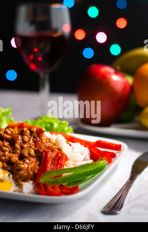 Dinner on tabletop with wine, fruits and bokeh lights in background. Stock Photo