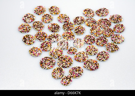 Retro Sweets - Jazzies (Chocolate Buttons with Hundreds and Thousands) shaped into a heart Stock Photo