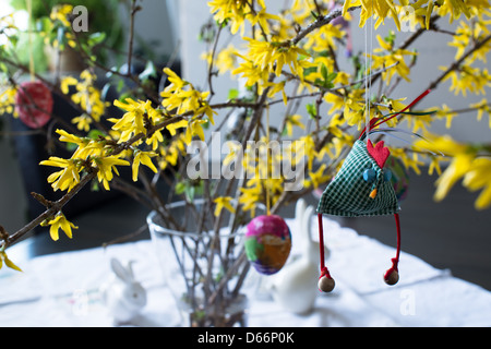 colorful easter bouquet with forsythia, eggs and a funny selfmade hen decoration Stock Photo