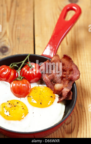Fried eggs with bacon and tomatoes Stock Photo