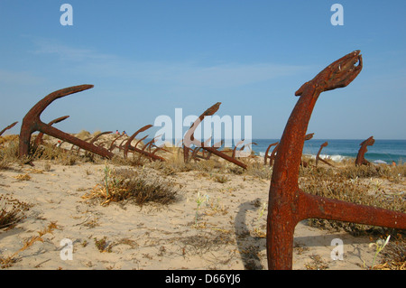 The Cemiterio das Ancoras Cemetery of Anchors / Anchor Graveyard a rusting memorial to the former fishing fleet, which comprises of the anchors used for tuna fishing embedded into the sand dunes close to the Praia do Barril Beach, located on the Ilha de Tavira in Algarve Southern region of Portugal Stock Photo