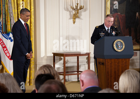 US President Barack Obama bows his head during a moment of prayer during the posthumous Medal of Honor award ceremony for US Army Chaplain Capt. Emil Kapaun in the East Room of the White House April 11, 2013 in Washington, DC. Father Kapaun was honored for his heroism during combat at Unsan, Korea and later died as a POW. Stock Photo