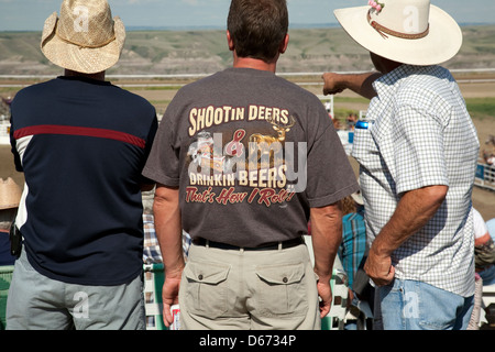 Three cowboys watch the rodeo in Drumheller, Alberta Stock Photo