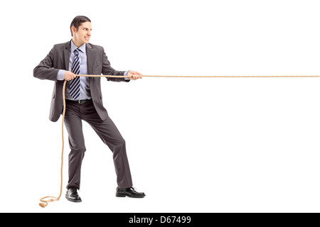 Full length portrait of a young businessman in suit pulling a rope isolated on white background Stock Photo