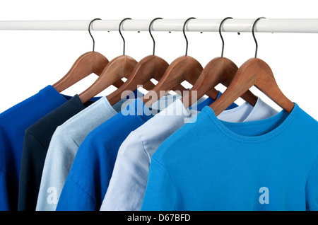 Choice of casual shirts on hangers, different tones of blue. Isolated on white. Stock Photo