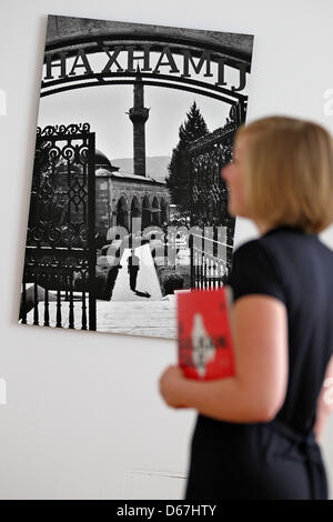 A woman looks at images in the exhibition 'A Balkan Tale' at th Art Collection in Chemnitz, Germany, 8 July 2012. The exhibition was initiated by the Goethe institute and shows 50 photographs of five Balkan photo artists until 2 September 2012. Chemnitz is the only non-Balkan station of the moving exhibition. Photo: Jan Woitas Stock Photo